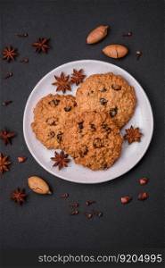 Delicious baked oatmeal raisin cookies on a dark concrete background. Sweets for breakfast