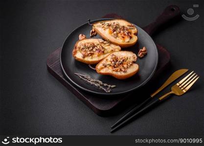 Delicious baked pear with dorblu cheese, walnut and honey on a textured concrete background. Vegetarian dish