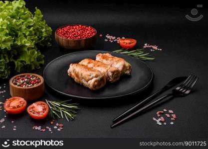 Delicious baked pork or chicken roll with mushrooms, spices and herbs inside on a dark concrete background