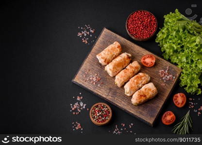 Delicious baked pork or chicken roll with mushrooms, spices and herbs inside on a dark concrete background