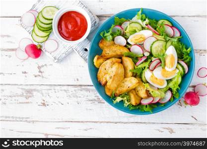 Delicious baked potato, boiled egg and fresh vegetable salad of lettuce, cucumber and radish. Summer menu for detox diet