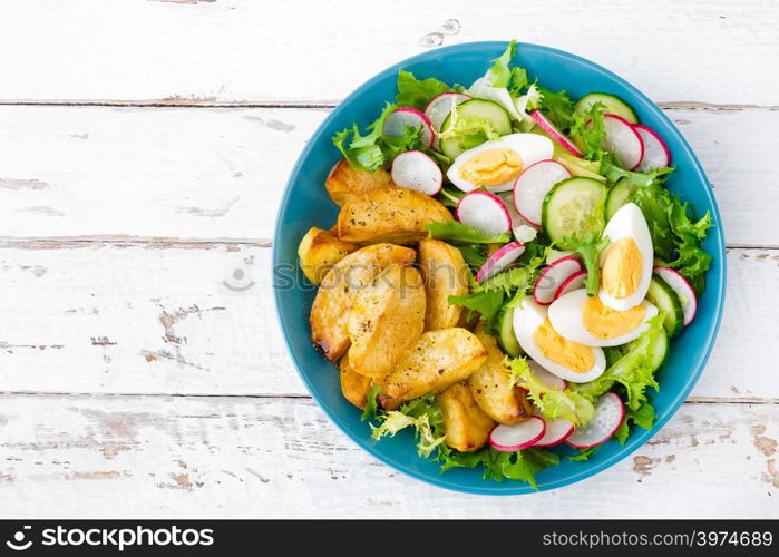 Delicious baked potato, boiled egg and fresh vegetable salad of lettuce, cucumber and radish. Summer menu for detox diet