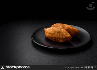 Delicious baked potato cutlet stuffed with chicken and vegetables, spices and salt on a dark concrete background