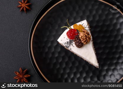 Delicious beautiful piece of cake with cream and berries on a black ceramic plate on a dark concrete background