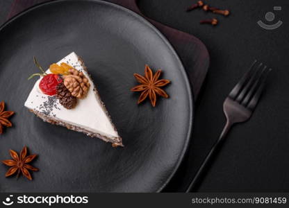 Delicious beautiful piece of cake with cream and berries on a black ceramic plate on a dark concrete background