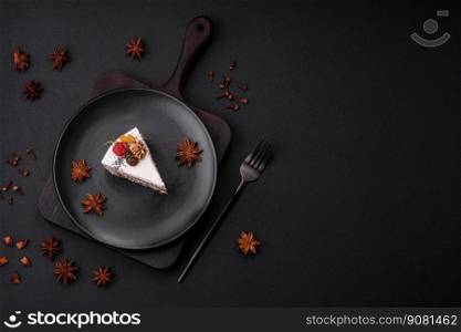 Delicious beautiful piece of cake with cream and berries on a black ceramic plate on a dark concrete background