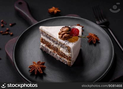 Delicious beautiful piece of cake with cream and berries on a black ceramic plate on a dark concrete background