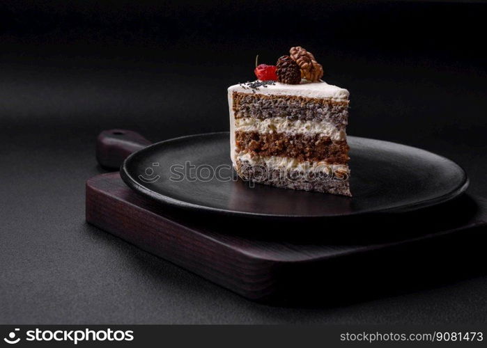 Delicious beautiful piece of cake with cream and berries on a black ceramic plate on a dark concrete background