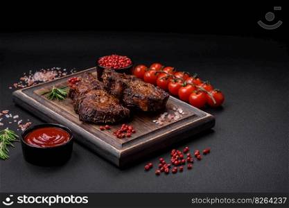 Delicious beef or pork steak on the bone grilled with spices and rosemary on a dark concrete background