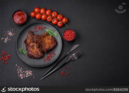 Delicious beef or pork steak on the bone grilled with spices and rosemary on a dark concrete background