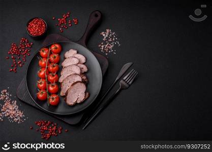 Delicious beef steak with salt, spices and herbs on a ceramic plate on a dark concrete background