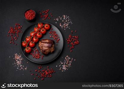 Delicious beef steak with salt, spices and herbs on a ceramic plate on a dark concrete background