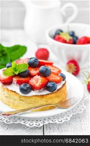 Delicious berry cheesecake with fresh strawberry and blueberry on white background