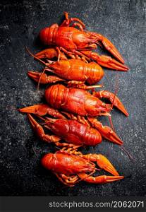 Delicious boiled crayfish on the table. On a black background. High quality photo. Delicious boiled crayfish on the table.