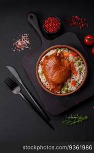 Delicious boiled rice with chicken and vegetables or risotto with salt, spices and herbs on a ceramic plate on a dark concrete background