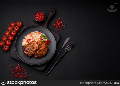 Delicious boiled rice with peppers, peas, asparagus beans and carrots and fried chicken on a textured concrete background