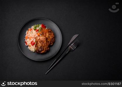Delicious boiled rice with peppers, peas, asparagus beans and carrots and fried chicken on a textured concrete background