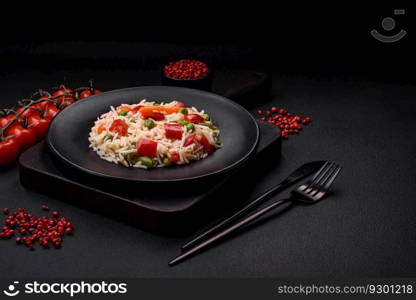 Delicious boiled rice with peppers, peas, asparagus beans and carrots on a textured concrete background