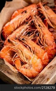 Delicious boiled shrimp on a wooden tray. Macro background. High quality photo. Delicious boiled shrimp on a wooden tray.