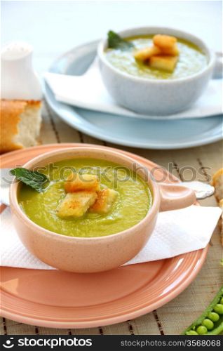 Delicious bowls of pea soup with fresh mint and crusty bread.