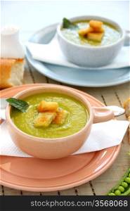 Delicious bowls of pea soup with fresh mint and crusty bread.