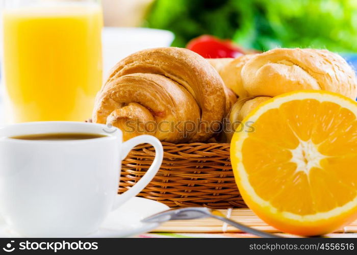 Delicious breakfast. Croissants and cup of coffee on breakfast table