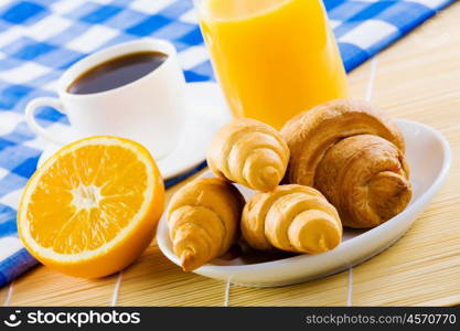 Delicious breakfast. Croissants and cup of coffee on breakfast table