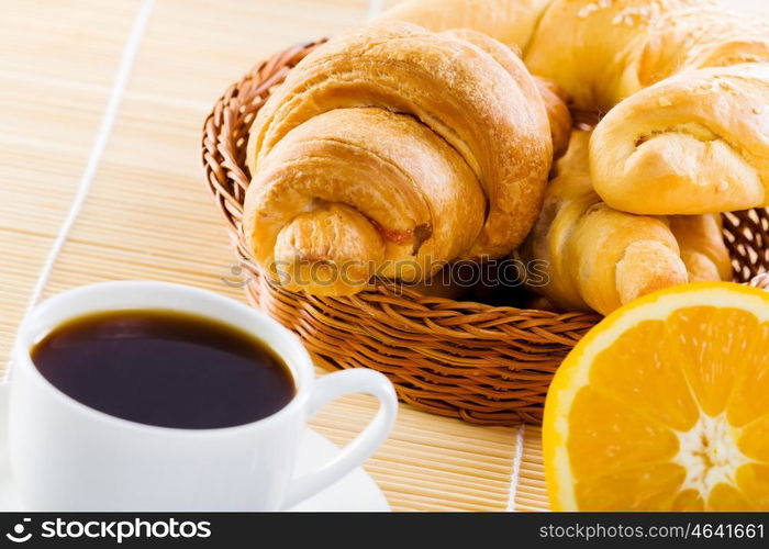 Delicious breakfast. Croissants and cup of coffee on breakfast table