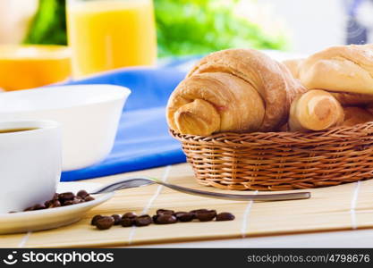 Delicious breakfast. Croissants and cup of coffee on breakfast table