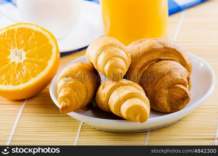 Delicious breakfast. Croissants and cup of coffee on breakfast table