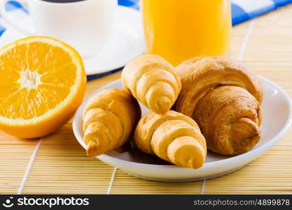 Delicious breakfast. Croissants and cup of coffee on breakfast table