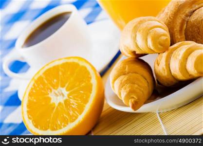 Delicious breakfast. Croissants and cup of coffee on breakfast table