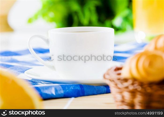 Delicious breakfast. Croissants and cup of coffee on breakfast table
