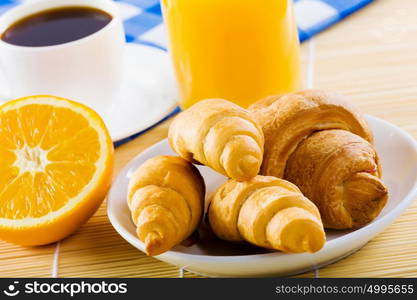 Delicious breakfast. Croissants and cup of coffee on breakfast table