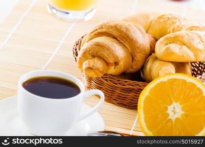 Delicious breakfast. Croissants and cup of coffee on breakfast table