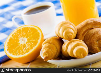 Delicious breakfast. Croissants and cup of coffee on breakfast table