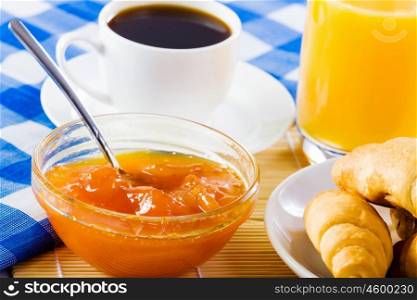 Delicious breakfast. Croissants jelly and cup of coffee on breakfast table