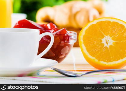 Delicious breakfast. Croissants jelly and cup of coffee on breakfast table