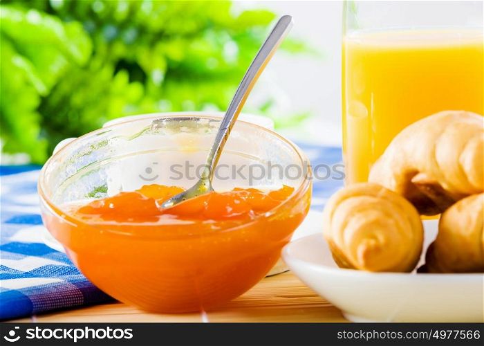 Delicious breakfast. Croissants jelly and orange juice on breakfast table