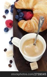 Delicious breakfast with fresh coffee, fresh croissants and fruits