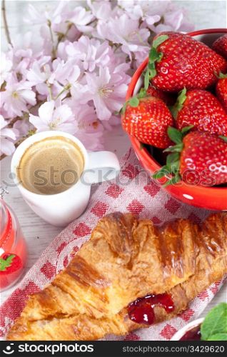 Delicious breakfast with hot coffee and fresh strawberries