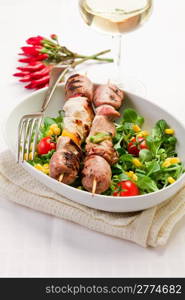 delicious broiled meat skewers on white table