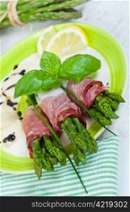 Delicious bunch of asparagus rolled with speck