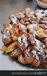 delicious buns - pretzels sprinkled with powdered sugar on a large tray