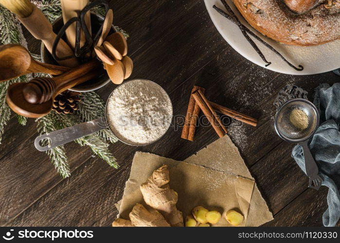 Delicious cake with pear, ginger and cinnamon on a dark kitchen counter.