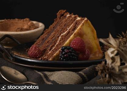 Delicious caramel cake slice with blackberries and raspberries.
