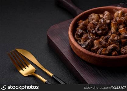 Delicious champignon mushrooms with salt, spices and herbs grilled in a ceramic plate