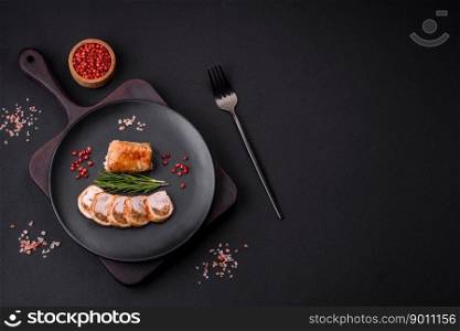 Delicious chicken or pork meat roll with mushrooms, cheese, spices and herbs on a dark concrete background