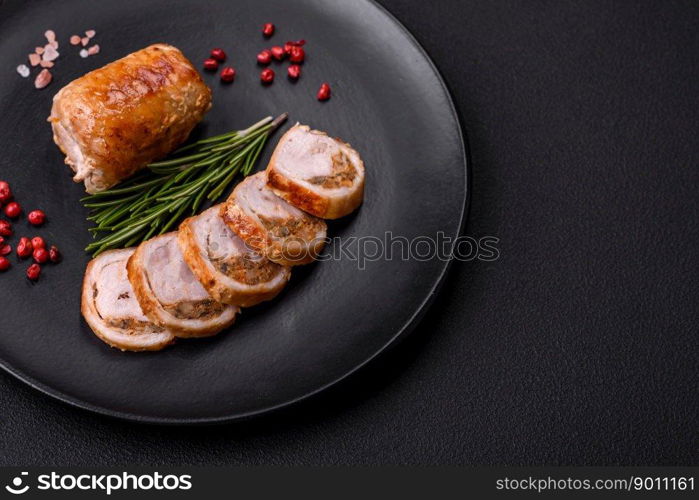 Delicious chicken or pork meat roll with mushrooms, cheese, spices and herbs on a dark concrete background