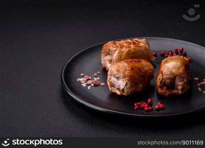 Delicious chicken or pork meat roll with mushrooms, cheese, spices and herbs on a dark concrete background
